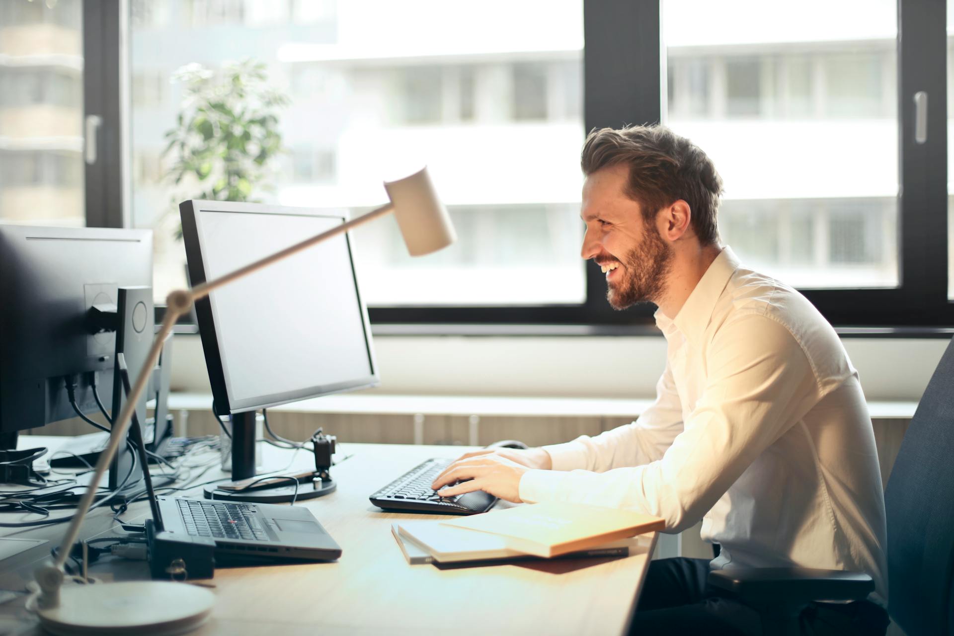 How to Build a Lead Funnel With Email Marketing image Man in White Dress Shirt Sitting on Black Rolling Chair While Facing Black Computer Set and Smiling